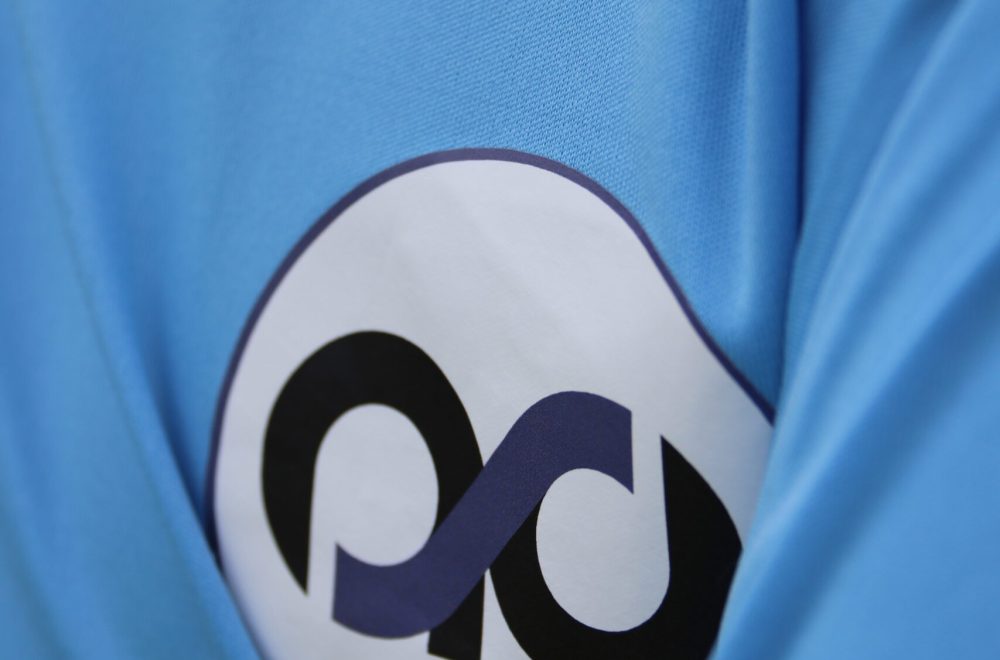 Logo de l'academie sportive des alpes sur le maillot d'un joueur.